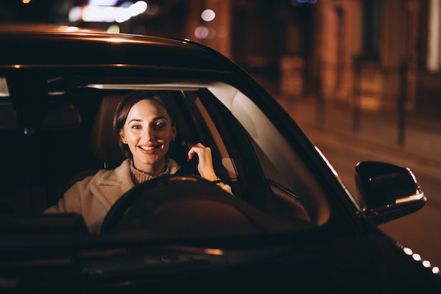 Free photo young woman in car holding safety belt