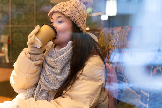 Free photo young woman drinking hot beverage