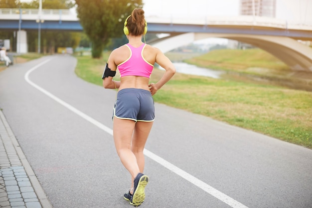 Free photo young woman exercising outdoor. sunny morning makes me feel good