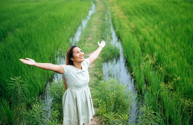 Free photo young woman happily in a green field at sunny day