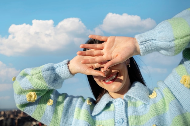 Free photo young woman hiding her face in an outdoor field