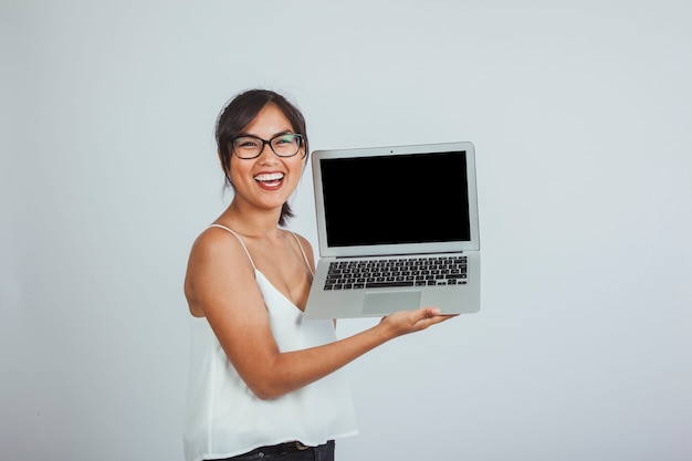 Free photo young woman laughing and holding the laptop