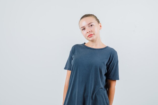 Young woman posing while looking in grey t-shirt