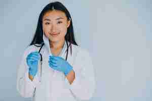 Free photo young woman surgeon on blue background with stethoscope