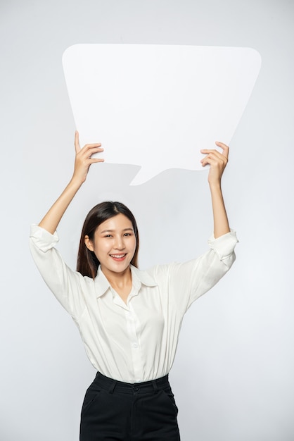 Free Photo a young woman in a white shirt holding a thought box symbol