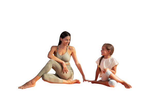 Female yoga instructor doing meditation with young girl