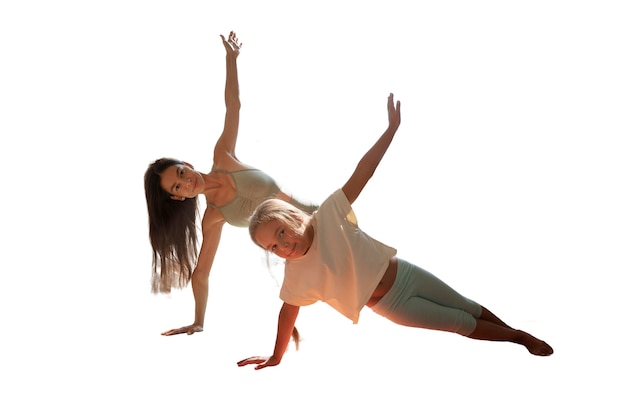 Female yoga instructor doing meditation with young girl