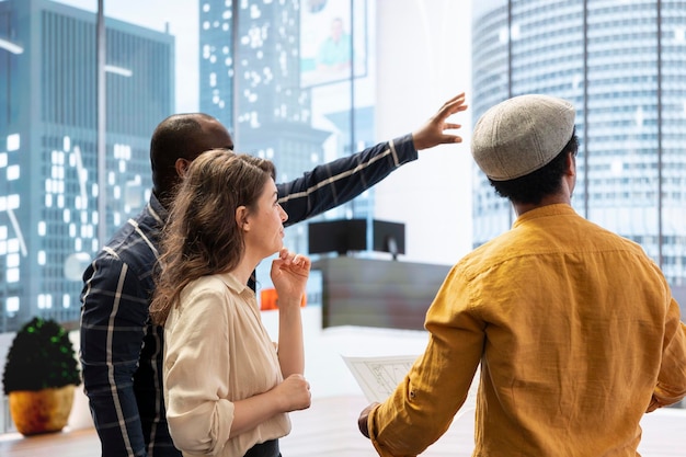 Photo gratuite un agent immobilier et des clients partagent leur vision de la conception de l'espace de travail lors d'une visite du bureau