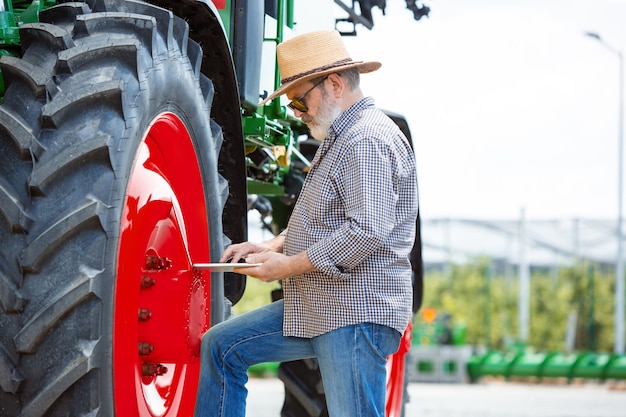 Photo gratuit un agriculteur avec un tracteur, combine dans un champ au soleil.