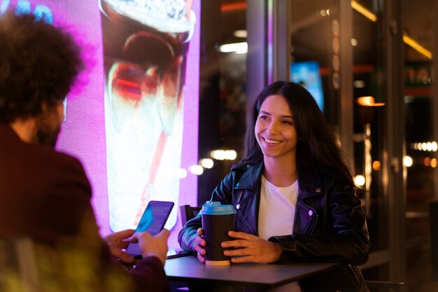 Amis assis à une table et buvant du café pendant une soirée