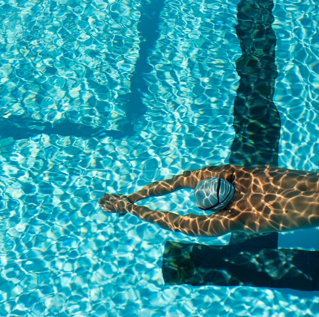 Photo gratuite angle élevé de nageur masculin nageant dans la piscine d'eau