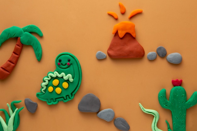 Photo gratuit art de pâte à modeler avec volcan et dinosaure