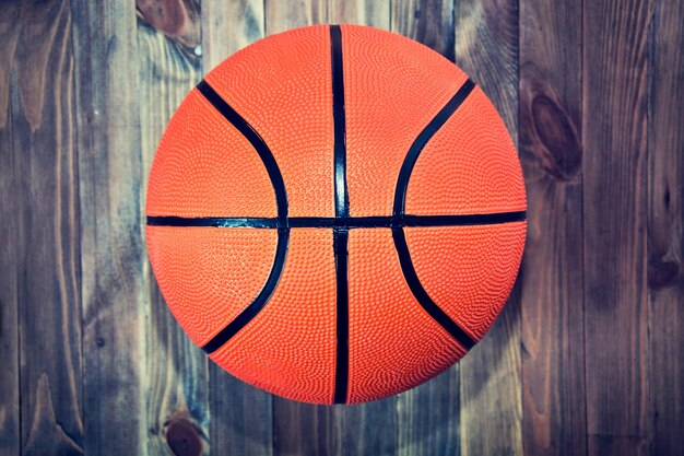 Balle de basketball sur parquet en bois.