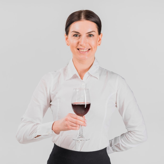 Photo gratuite barkeeper souriant et tenant un verre de vin