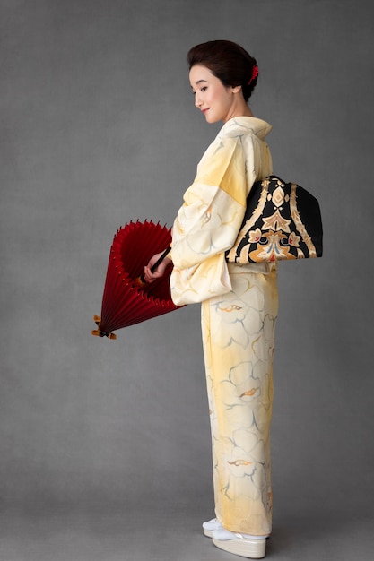 Photo gratuite beau modèle japonais avec un parapluie rouge