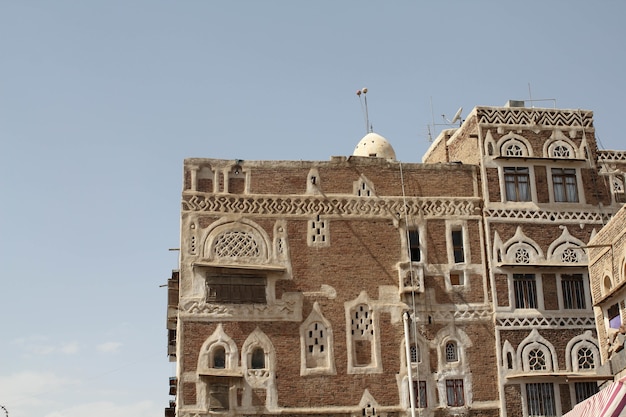 Photo gratuit beau vieux bâtiment sous la lumière du soleil et un ciel bleu à sanaa, yémen