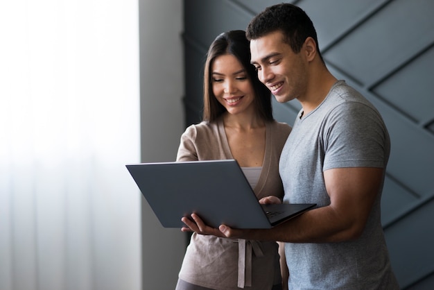 Bel homme et femme travaillant sur un ordinateur portable