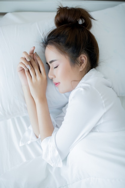 Photo gratuite belle jeune femme couchée dans le lit et dormant.