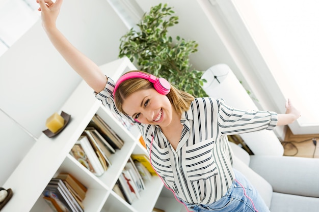 Photo gratuite belle jeune femme écoutant de la musique à la maison.