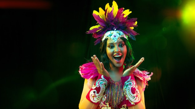 Belle jeune femme en masque de carnaval, costume de mascarade élégant avec plumes et cierges magiques invitant