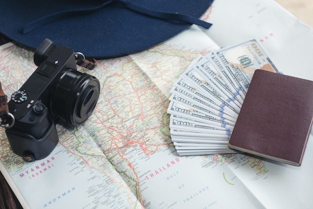 Billets de dollar, carte de crédit, passeport, appareil photo et chapeau bleu