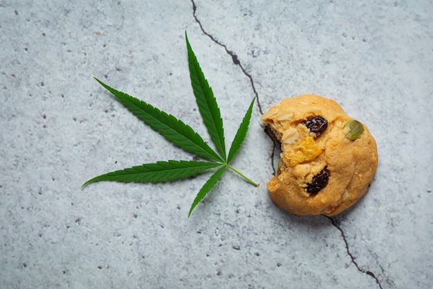 Photo gratuit biscuit au cannabis et feuille de cannabis posé sur le sol