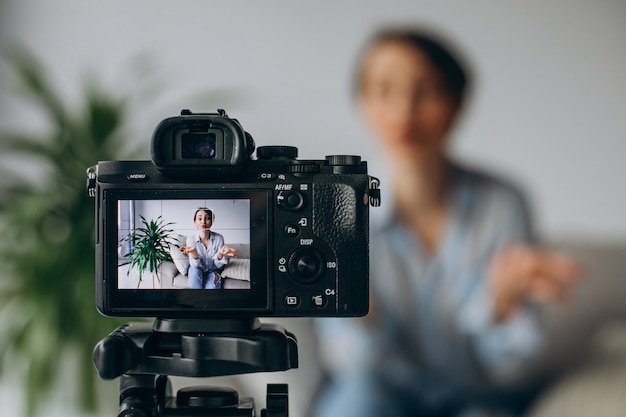 Photo gratuite blogueur de jeune femme enregistrant la vidéo sur l'appareil-photo