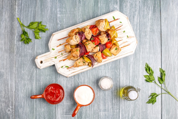 Photo gratuite brochette de poulet shish aux légumes, ketchup, mayonnaise