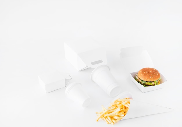 Photo gratuite burger; frites; coupe d'élimination et colis de nourriture mock up sur fond blanc