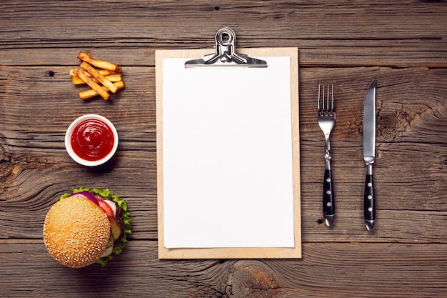 Photo gratuite burger à plat avec presse-papiers de maquette