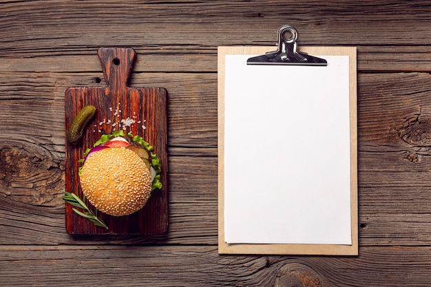 Photo gratuite burger à plat avec presse-papiers de maquette