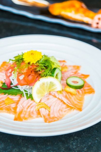 Carpaccio de saumon dans une assiette blanche