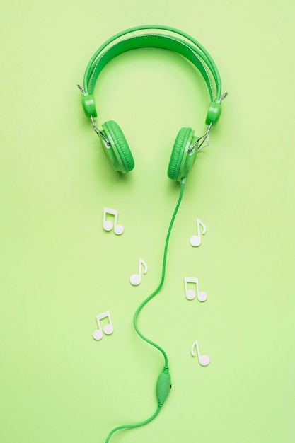 Photo gratuite casque vert avec des notes de musique blanches