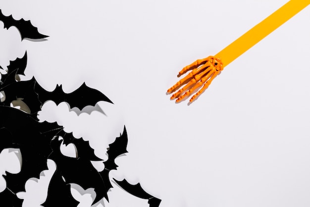 Photo gratuite chauves-souris décoratives d'halloween près d'une main squelette