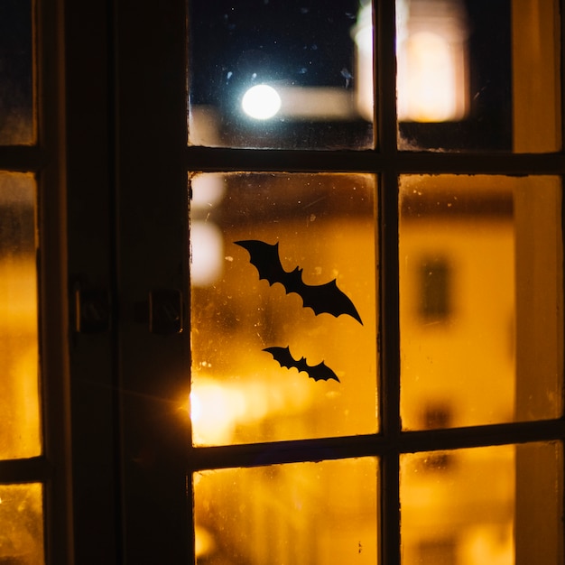 Photo gratuite chauves-souris d'halloween collées sur la fenêtre