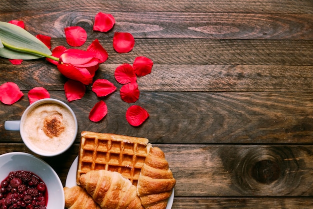 Confiture dans un bol, fleur fraîche, boulangerie, pétales et tasse de boisson