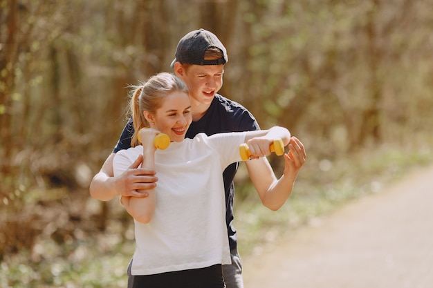 Photo gratuit couple de sportifs s'entraînant dans une forêt d'été