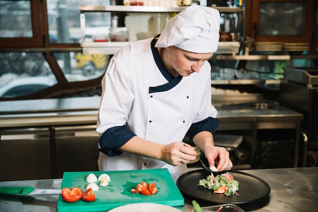 Photo gratuite cuire en mettant l'oeuf à la coque sur une assiette avec une salade