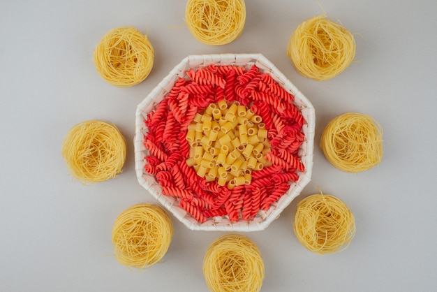 Photo gratuite délicieux macaronis crus colorés sur assiette