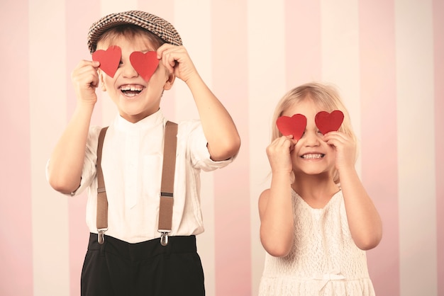 Photo gratuite deux enfants avec des cœurs sur les yeux