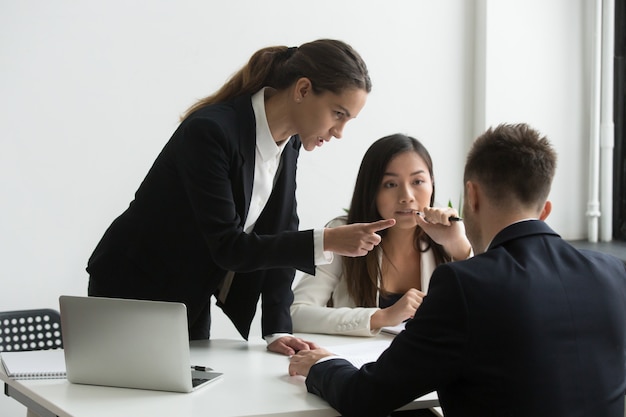 Photo gratuite un dirigeant féminin insatisfait blâmant un employé masculin menaçant lors d'une réunion d'équipe