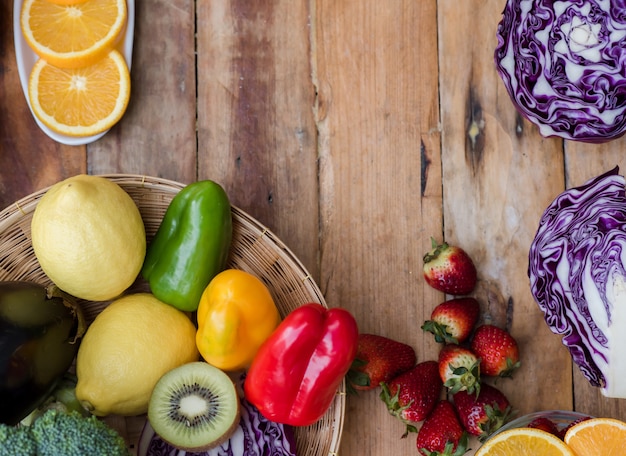 Photo gratuite divers fruits aux légumes sur fond de bois