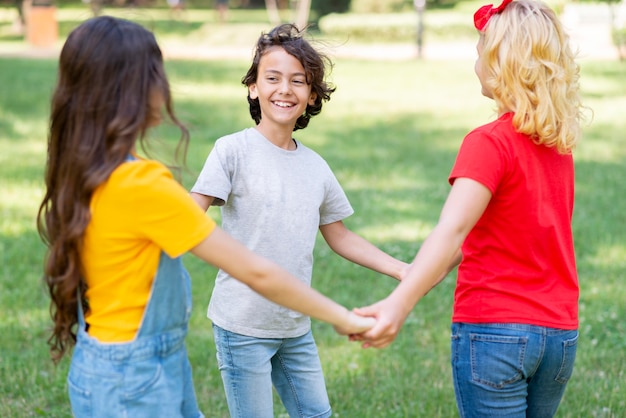 Photo gratuite enfants à angle élevé, main dans la main