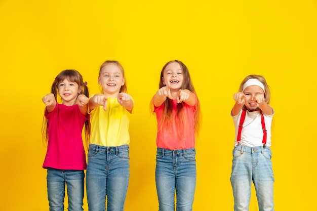 Photo gratuit enfants heureux jouant et s'amusant ensemble sur le mur jaune