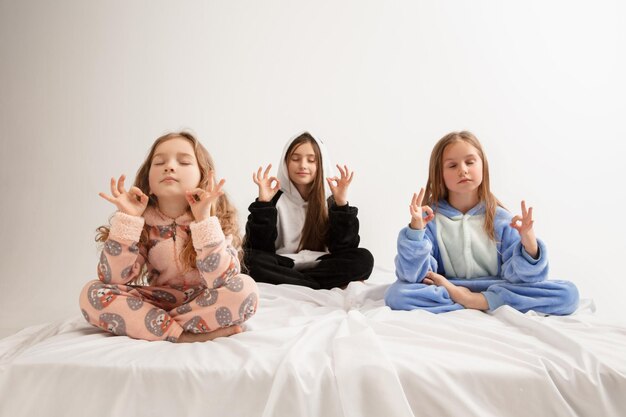 Enfants en pyjama doux et chaud ayant une fête colorée jouant à la maison