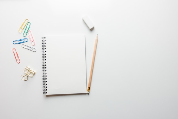 Photo gratuite espace de travail minimal - photo créative de la table plate du bureau de l'espace de travail avec un carnet de croquis et un crayon en bois sur un fond de copie fond blanc. vue de dessus, photographie plate.