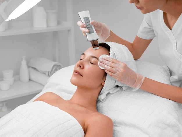 Esthéticienne faisant la routine de beauté du visage pour une cliente