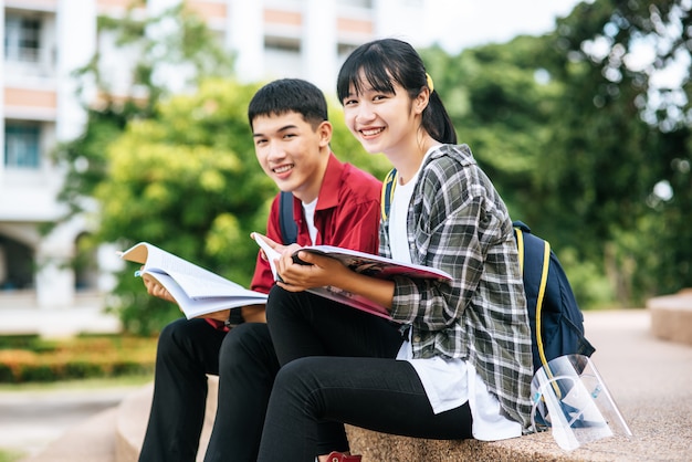 Photo gratuite les étudiants et étudiantes assis et lisant des livres dans les escaliers.