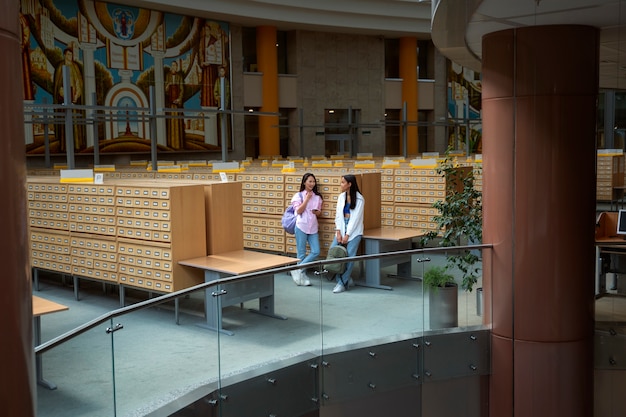 Photo gratuite Étudiants souriants à long terme discutant