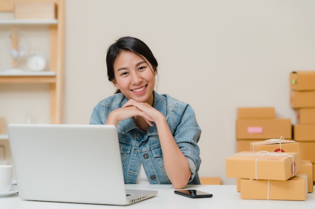 Photo gratuite femme d'affaires se sentant heureuse en souriant et en regardant vers la caméra alors qu'elle travaillait dans son bureau à la maison.